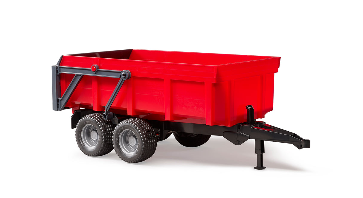 A red toy trailer with automatic tailgate, featuring a tilting trough and a fold-down support leg, made from high-quality plastics.
