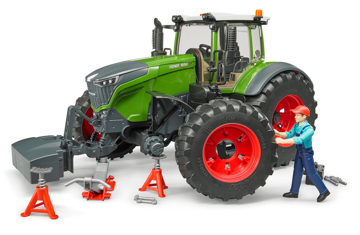 A green Fendt 1050 Vario toy tractor with mechanic and workshop equipment, including a figure of a mechanic and various tool accessories.
