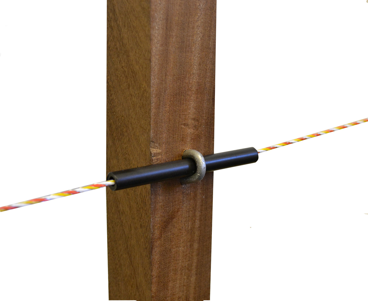 A close-up image of a black tube insulator installed on a wooden post, with a coloured electrical fence wire running through it.