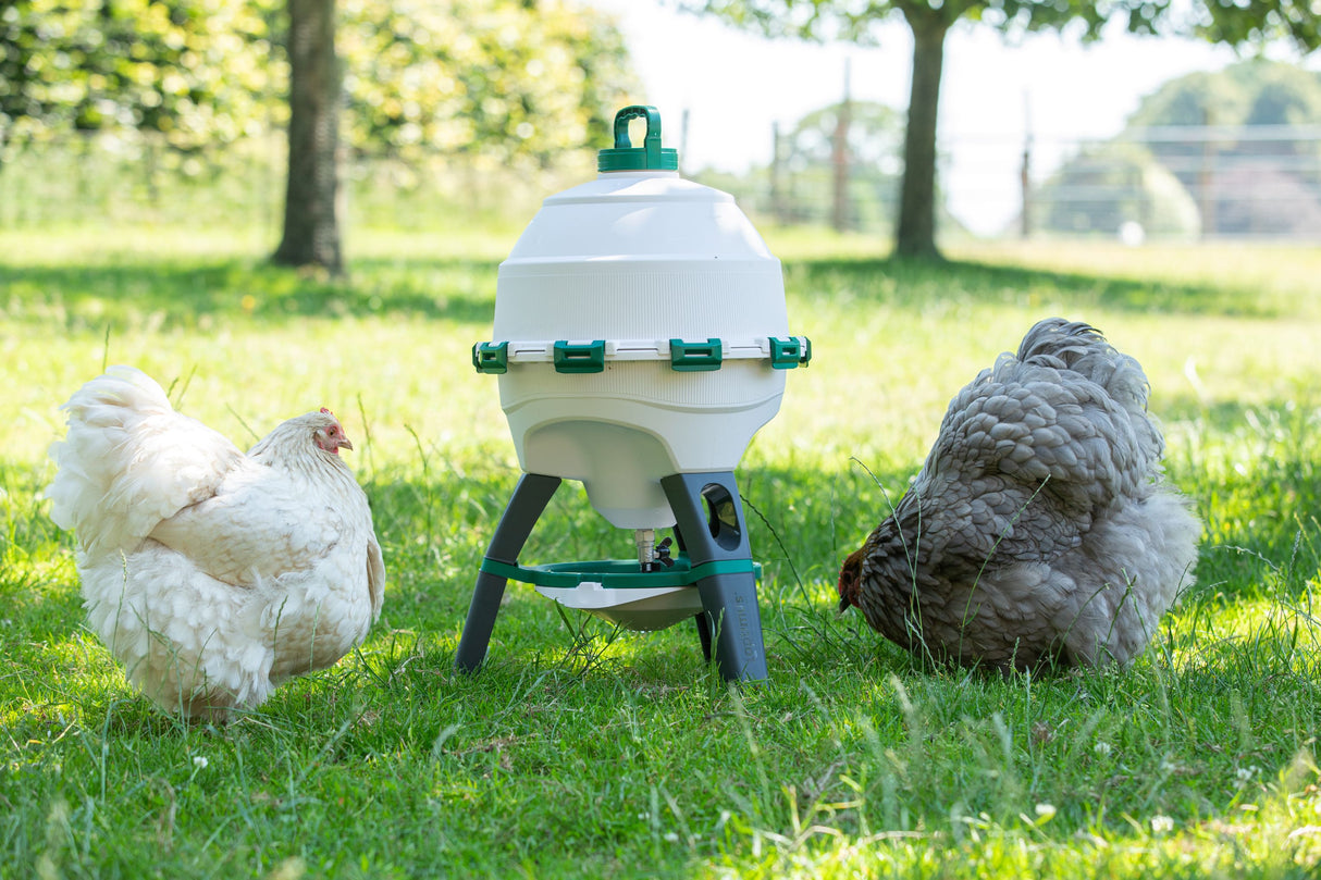 A white tripod-mounted Optimus bird drinker with two birds on either side in an outdoor setting.