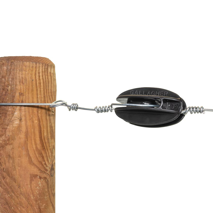A black Gallagher corner insulator attached to a wooden fence post, with a section of wire attached to it.