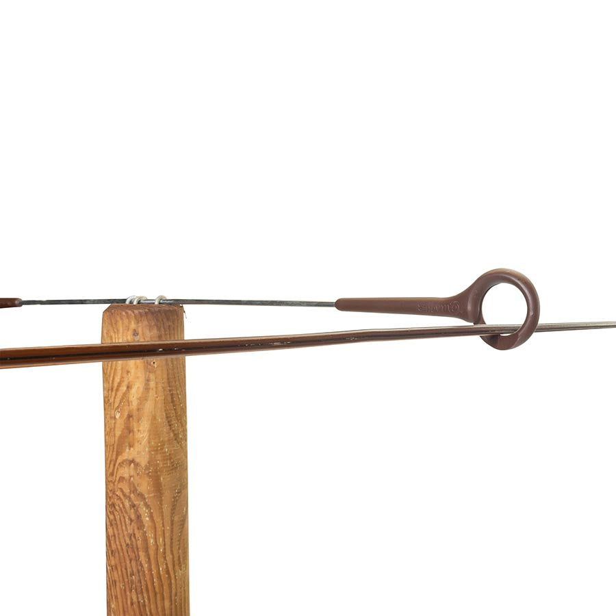 A close-up of the Gallagher Offset Double Pigtail, showing a terracotta-colored insulator mounted on a wooden post.
